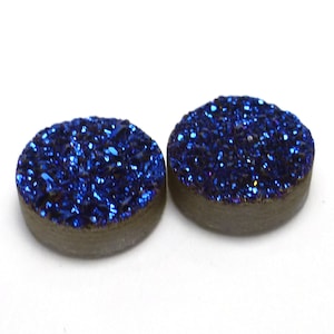 May include: Two round, blue, sparkly, iridescent, agate cabochons. The cabochons are approximately 1 inch in diameter.