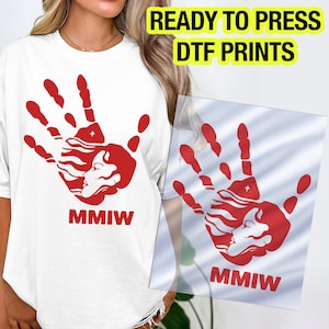 May include: White t-shirt with a red handprint design featuring a woman's profile and the letters "MMIW". The image also shows a clear DTF print with the same design and the text "READY TO PRESS DTF PRINTS".