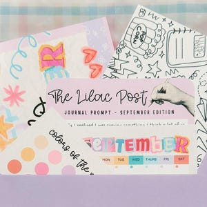 May include: A light purple envelope containing several paper items including a journal prompt card titled The Lilac Post September Edition, a black and white doodle sheet with popcorn and rainbows, and a sheet of colorful circular stickers.