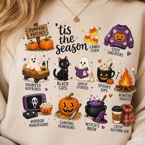 Può includere: Una felpa beige con una stampa grafica che riporta il testo 'tis the season e varie illustrazioni autunnali e di Halloween, tra cui zucche, un gatto nero, fantasmi, un calderone, un falò e maglioni con le relative etichette descrittive.