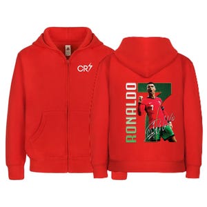 May include: Red zip-up hoodie featuring the CR7 logo on the chest. The back displays a graphic of Cristiano Ronaldo in a Portugal jersey, with the name "RONALDO" in green and white.