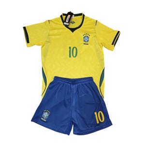 May include: A yellow and blue soccer uniform set. The jersey is yellow with green and black accents, the number 10, and a team emblem. The shorts are blue with the number 10 and a team emblem.