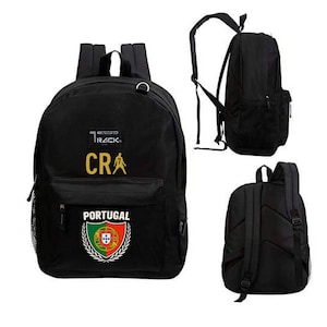 May include: Black backpack with the word "TRACK" above the letters "CRA" in gold. The word "PORTUGAL" is below a crest with the Portuguese flag. The backpack has a front pocket and side mesh pocket.