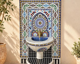 May include: A wall-mounted fountain featuring intricate geometric and floral tile patterns in blue, green, yellow, and red. The structure includes a central brass spigot, a semi-circular marble basin, and a base decorated with black and white tiles.
