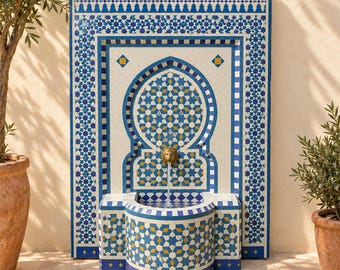 May include: A rectangular wall fountain featuring intricate blue, white, and yellow geometric tile patterns. The fountain has a central arched niche with a brass lion head spout that releases a thin stream of water into a curved basin below.