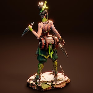 May include: A green and brown action figure of a female warrior with a green and brown outfit, holding a weapon in each hand. The figure is standing on a rocky base with green plants.
