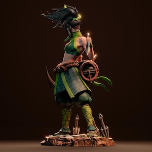 May include: A green and black action figure of a female character with long black hair, a green and black outfit, and a weapon. The figure is posed in a fighting stance with a weapon in her hand. The figure is standing on a rocky base with several smaller weapons scattered around it.