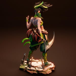 May include: A green and black action figure of a female character with long black hair, a green mask, and a green and black outfit. The figure is holding a curved blade and is standing on a rocky base.