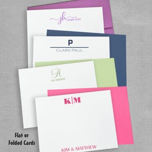 May include: A collection of white stationery cards and colorful envelopes. The cards feature personalized names and monograms including Jasmine Heinz, Clark Paul, Lisa Anderson, and Kim & Matthew. The text Flat or Folded Cards is visible.