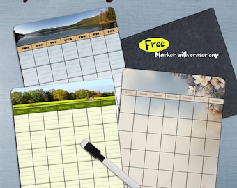 May include: Dry erase magnetic calendars with scenic backgrounds. The calendars have a grid layout for daily planning. A free marker with an eraser cap is included. The text "Dry Erase Magnetic Calendars" is at the top.