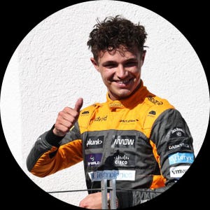 May include: A young man in a black and yellow racing suit with various sponsor logos, including Hilton,  Plunk, Arrow, Cisco, and Technip Energies. He is giving a thumbs up.