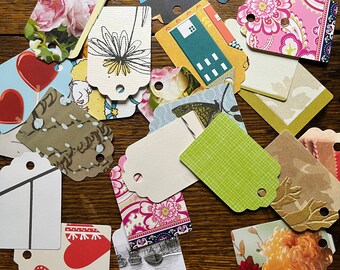 Puede incluir: Surtido de etiquetas de papel con patrones coloridos de diversas formas y diseños. Algunas etiquetas presentan patrones florales, otras diseños geométricos y otras tienen texto. Las etiquetas son perfectas para agregar un toque personal a regalos, manualidades u otros proyectos.