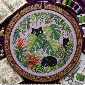 Peut inclure: Un tambour à broder circulaire contenant un motif au point de croix sur tissu lavande. Le design présente trois chats noirs nichés parmi des feuilles de monstera vertes, des fougères et des broméliacées orange-rouge. Le cadre est orné.