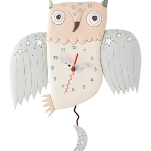 May include: A white owl-shaped clock with a pendulum shaped like a crescent moon. The clock face has a white background with black and blue hands, and blue numbers. The owl has grey wings with white stars.