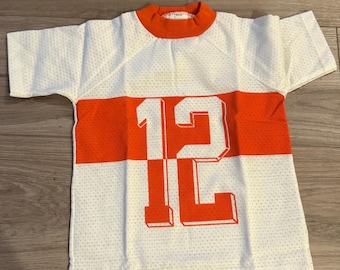 Camiseta deportiva para niño, nueva, sin usar. Número 12, naranja y blanca. Talla 6.