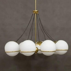 Pu&ograve; includere: Un lampadario moderno con pi&ugrave; luci a globo bianche con finiture color oro. Il lampadario ha un supporto centrale color oro e cavi neri che sospendono i globi. Il design &egrave; elegante e contemporaneo, adatto a vari stili di interni.