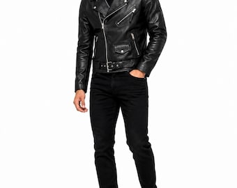 May include: A black leather motorcycle jacket with silver zippers, a waist belt, and shoulder epaulets, worn over a black t-shirt with black jeans and white sneakers. The outfit includes dark-tinted sunglasses with black frames.