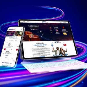 May include: A smartphone, tablet, and keyboard are displayed against a blue background with neon streaks. The tablet shows a website with the text "Elevating Your Experience Together" and "one7star". The smartphone displays plan options.