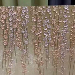 Puede incluir: Arte mural abstracto con un dise&ntilde;o texturizado de flores en cascada en tonos dorados, plateados y bronce. La obra de arte tiene un fondo neutro y un efecto tridimensional, creando una est&eacute;tica moderna y elegante.