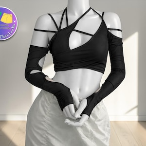 Könnte beinhalten: Schwarzes Neckholder-Top mit ausgeschnittenen Ärmeln und passendem Design. Das Top hat ein einzigartiges Trägerdesign und wird mit einer weißen Hose kombiniert. Die Schaufensterpuppe steht vor einer weißen Wand. Das Logo oben links lautet "Tankette Chic Looks".