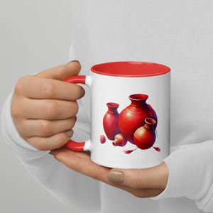 May include: White ceramic mug with a red rim and handle. The mug features a colourful illustration of four red clay pots.