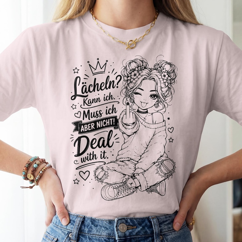 May include: A light pink t-shirt featuring a black line art graphic of a person with double buns, wearing a sweater and ripped jeans, giving the middle finger. The text reads: L&auml;cheln? Kann ich. Muss ich ABER NICHT! Deal with it.