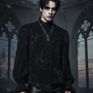 May include: Black long-sleeve shirt with a high collar and decorative buttons. The shirt has a textured pattern and flared sleeves. A silver necklace with a pendant is visible. The shirt is part of a gothic fashion collection.