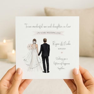 May include: A square white wedding greeting card featuring an illustration of a bride in a white gown and a groom in a black suit. Text reads: To our wonderful son and daughter-in-law, ON YOUR WEDDING DAY, Ryan & Nicki, 18.09.2025, Wishing you a lifetime of happiness together.