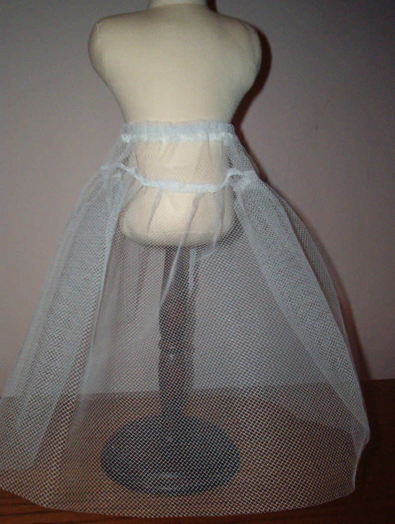 K&ouml;nnte beinhalten: Wei&szlig;er T&uuml;ll-Petticoat mit gerafftem Bund. Der Petticoat wird auf einer Schaufensterpuppe pr&auml;sentiert.
