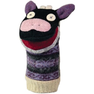 May include: A black and purple felt hand puppet with a pink nose, red mouth, and white button eyes. The puppet is wearing a purple and gray striped sweater with a white cuff.