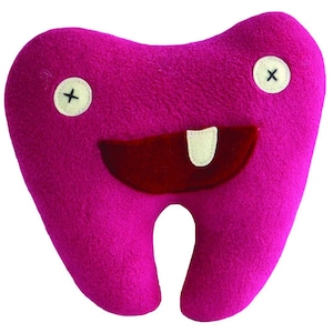 May include: A plush pink tooth with a smiling face, two black X's for eyes, and a red mouth with a white tooth sticking out.