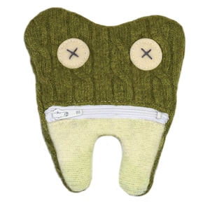 May include: Green knitted tooth-shaped plush toy with a zippered pocket and two black button eyes with an X stitched on each.