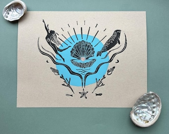 May include: A black and white print of a mermaid, a seal, and a seashell with a pearl inside. The image is surrounded by a blue circle and black seaweed.
