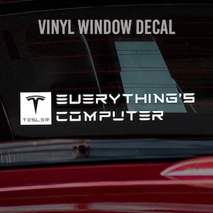 May include: White vinyl window decal with the text "VINYL WINDOW DECAL" at the top. Below, the decal features the Tesla logo and the words "EVERYTHING'S COMPUTER" in a bold, sans-serif font. The decal is displayed on a car window.