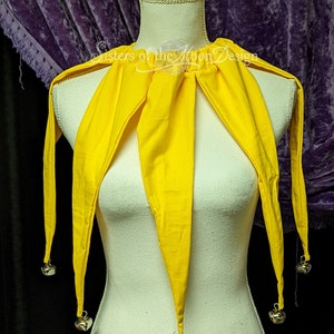 May include: A yellow jester's collar with bells on the ends of the points. The collar is made of fabric and is tied around the neck.