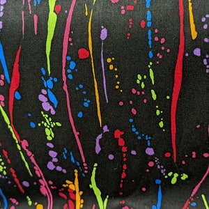 May include: Black fabric with a colorful abstract pattern of splattered paint and streaks. The colors include red, orange, yellow, green, blue, and purple.