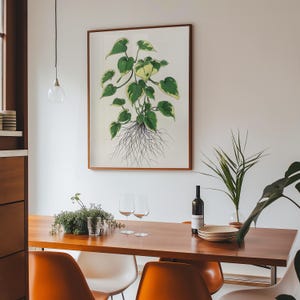 Puede incluir: Una ilustración botánica enmarcada de una planta verde y amarilla con raíces, colgada en una pared blanca sobre una mesa de comedor de madera con dos sillas naranjas, dos sillas blancas y una copa de vino.