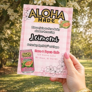 May include: Pink baby shower invitation with the text "Aloha Made" and "Leimomi". Includes a can of Aloha Natural Guava juice. The invitation is held by a person with gold bracelets.