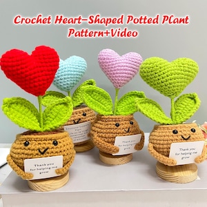 May include: A collection of crocheted heart-shaped potted plants in various colours, including red, blue, pink, and green. Each pot has a smiling face and a sign saying "Thank you for helping me grow." The text "Crochet Heart-Shaped Potted Plant Pattern+Video" is at the top.