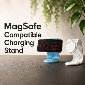 May include: A light blue and a white MagSafe Compatible Charging Stand. The blue stand holds a smartphone displaying a clock and calendar. The white stand is empty, showing a circular magnetic charging surface. The text reads MagSafe Compatible Charging Stand.