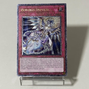 Könnte beinhalten: Eine holografische "Dominus Impulse" Fallenkarte mit rosa Rand. Die Karte zeigt eine detaillierte Illustration von zwei Figuren mit Flügeln und aufwendiger Kleidung. Der Text auf der Karte enthält den Kartennamen, den Typ und Spielanweisungen.