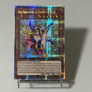 May include: A holographic trading card featuring "Dark Magician Girl the Magician's Apprentice." The card depicts a female anime character in a blue and pink outfit. The card has text describing its special abilities, with ATK/2000 and DEF/1700 stats.