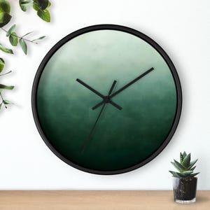 May include: A white ceramic mug with a black handle and the text "But First, Coffee" in a bold, black font. The mug is filled with a dark liquid, likely coffee, and sits on a light-colored surface.