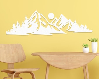 May include: White silhouette of a mountain range with a sun and trees on a yellow wall. A wooden table and chairs are in the foreground with potted plants.