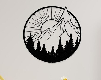 May include: Black metal wall art depicting a mountain range with a sun and trees in a circle. The art is hanging on a white wall in a living room setting with a yellow armchair, two side tables, and a potted plant.