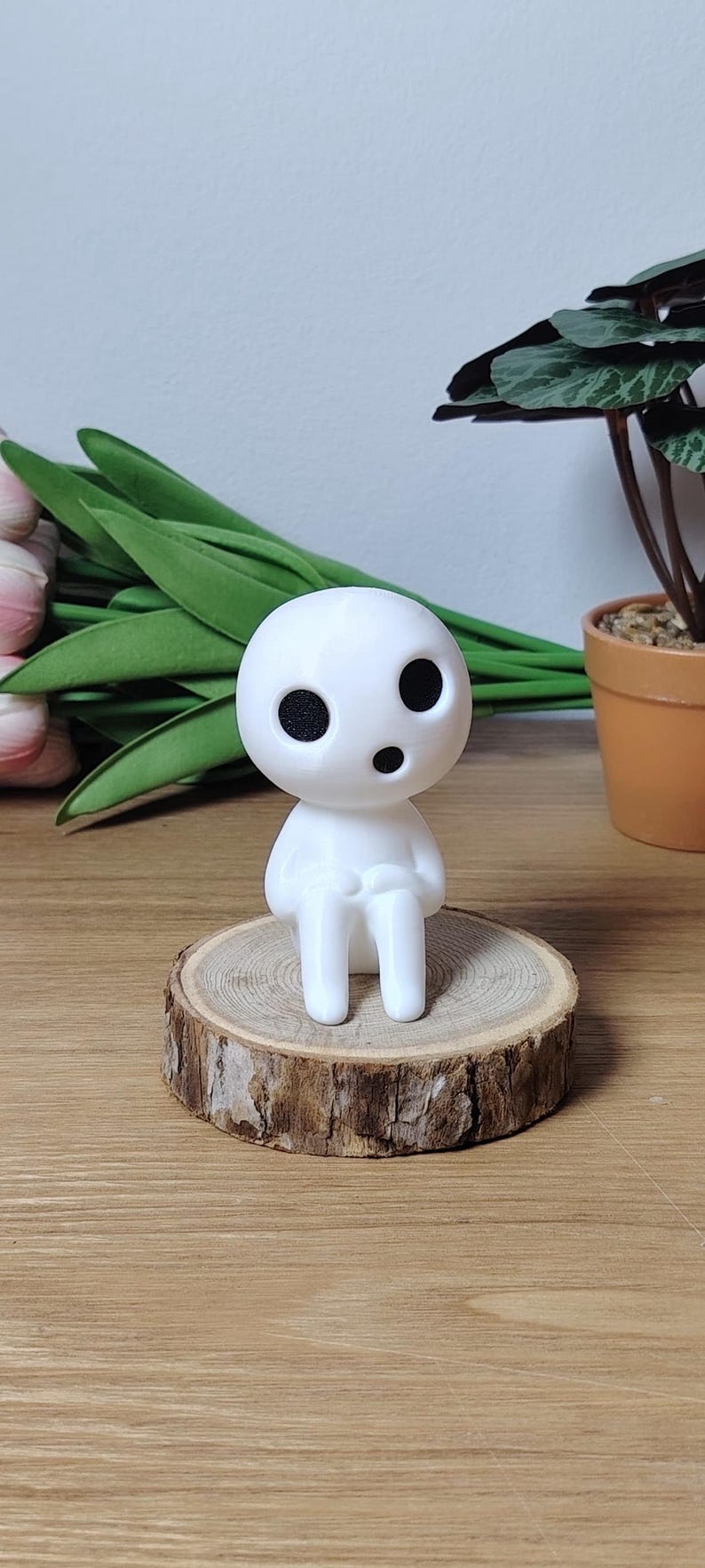 K&ouml;nnte beinhalten: Wei&szlig;e 3D-gedruckte Figur eines Charakters aus dem Film "Mein Nachbar Totoro". Die Figur sitzt auf einer Holzscheibe.