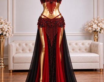 May include: A two-piece belly dance costume featuring a halter-style bra top and a floor-length skirt. The set is adorned with intricate black and red beadwork, sequins, and long dangling beaded fringe accents on the bodice and waist.