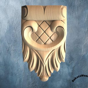 May include: A light-colored wooden corbel featuring a carved scroll top, a central diamond-patterned grid, and a bottom section with vertical leaf-like carvings. The text BukataWoodwork is printed in black in the bottom right corner of the image.