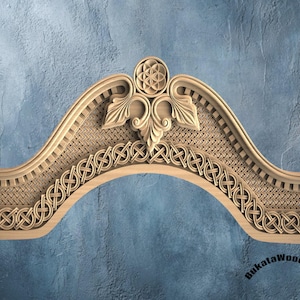 May include: A carved wooden architectural element with intricate Celtic knot and floral designs. The piece is arched, with a woven texture in the center and a decorative top. The wood has a natural, light brown color.
