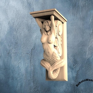 May include: A light-colored wooden corbel featuring a carved mermaid figure with a fish tail, positioned beneath a flat rectangular top shelf. The wood carving displays intricate details of the figure and scrollwork. Text reads BukataWoodwork.